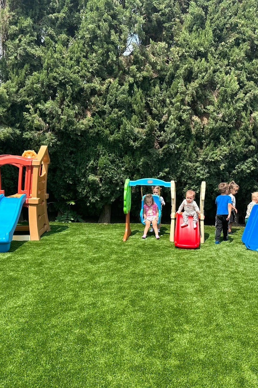 Children playing on slides in the outdoor play yard at Shila’s Daycare in Reseda.